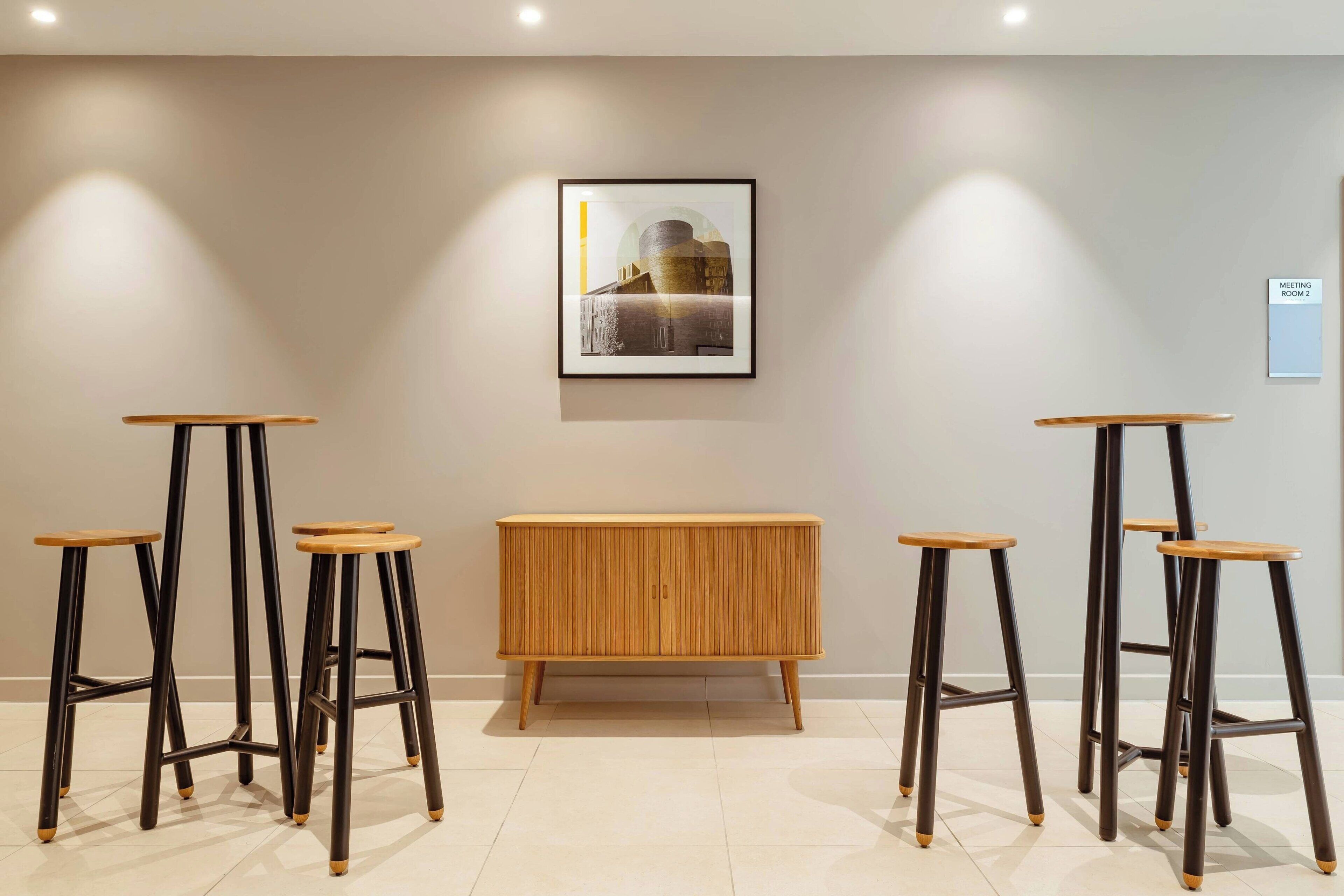 Een modern interieur met een houten console tafel en vier barkrukken.