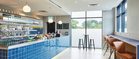 A modern bar area with blue-tiled counters, hanging pendant lights, and bar stools.