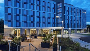 Un hotel moderno con un patio que ofrece mobiliario exterior y jardineras.