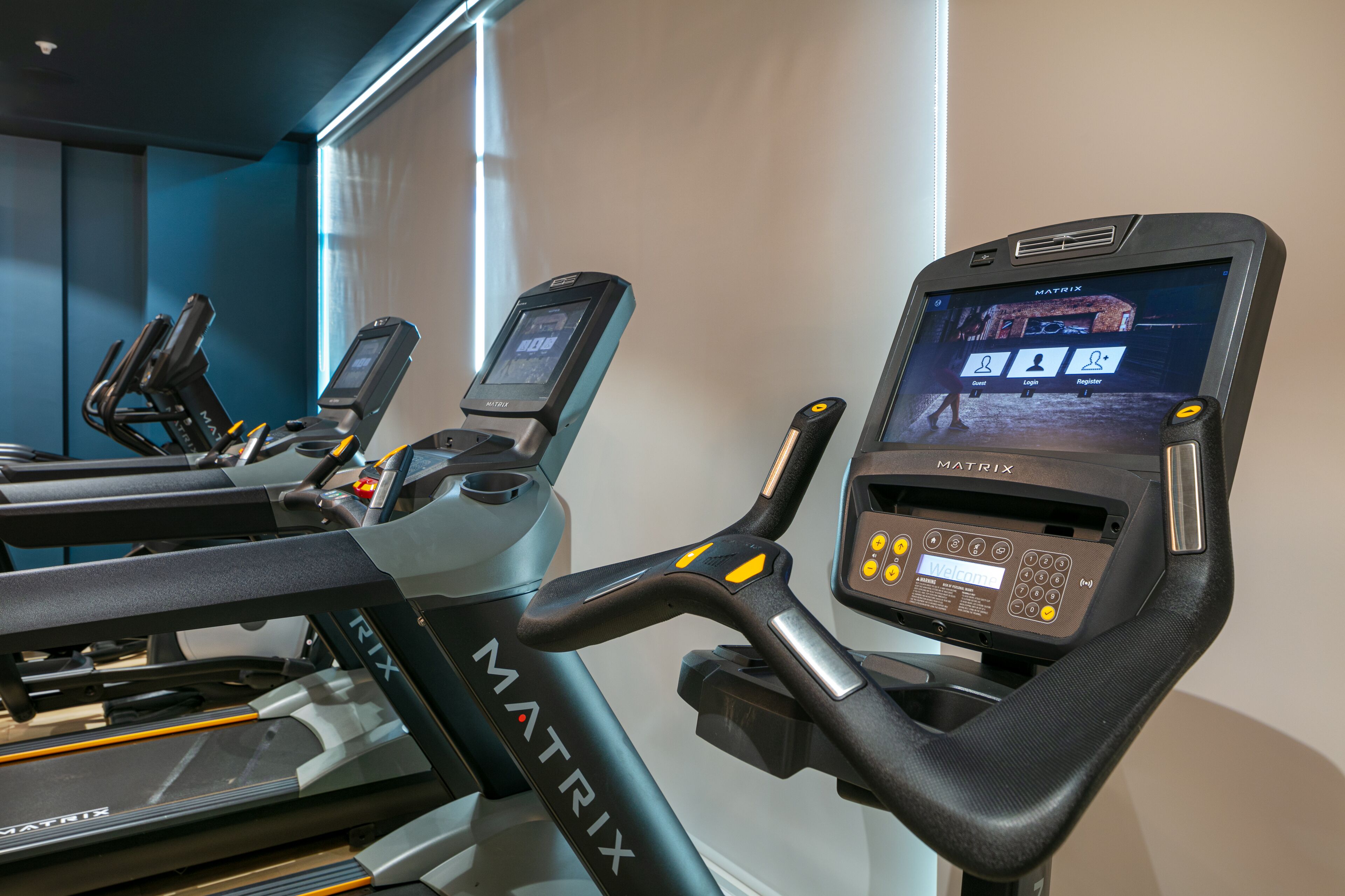 Un tapis roulant con display digitale e pannello di controllo, parte di un'attrezzatura da palestra.