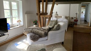 A cozy room with a bed, a wooden chair, a lamp, and a television. - Urlaub in der Zauberhaft Renovierten Krümelkate (Witzwort)
