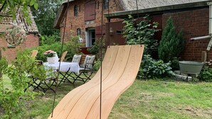 A wooden slide in a backyard with a brick house in the background. - Urlaub in der Zauberhaft Renovierten Krümelkate (Witzwort)