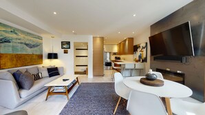 A modern apartment with a living room, dining area, and kitchen.