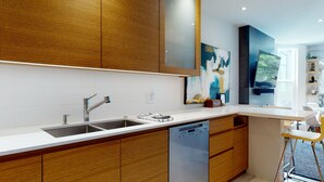 A modern kitchen with wooden cabinets, a stainless steel sink, and a dishwasher.