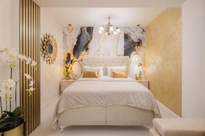 Un dormitorio con una cama grande, una araña y detalles decorativos en las paredes.