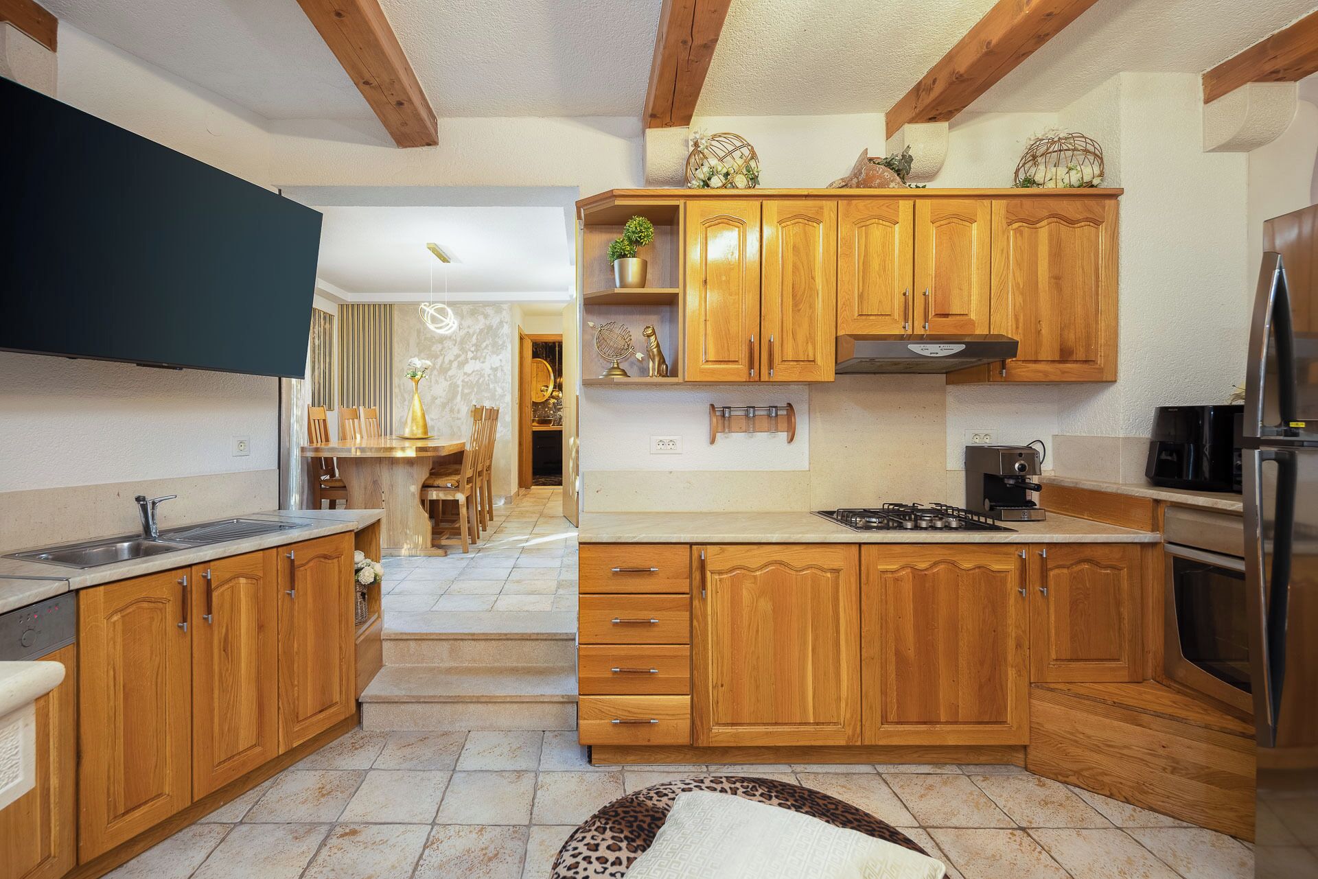A kitchen with wooden cabinets, a gas stove, and a refrigerator.