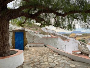 A stone pathway leading to a blue door, surrounded by white walls and a tree providing shade. - Modern villa with a private pool, located on the "LA FINCA GOLF" estate (Algorfa)