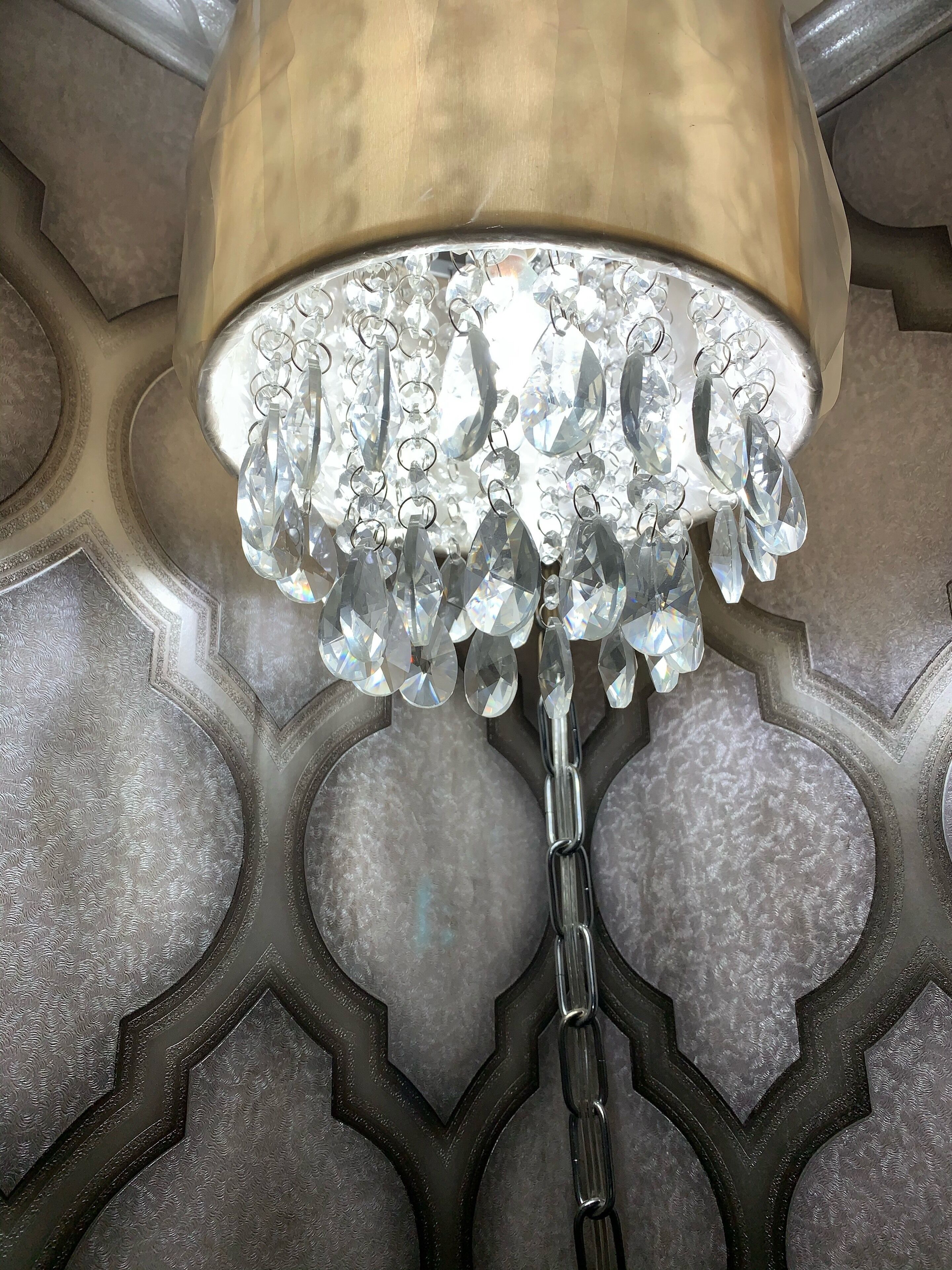 A chandelier with multiple crystal elements hanging from a metallic structure.