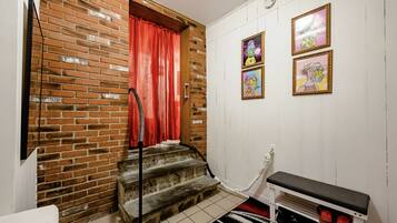 A staircase with a red curtain, a bench, and a shoe rack.