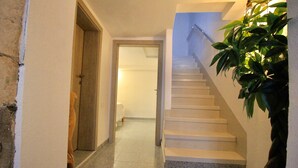 Eine Treppe mit Geländer, einem Blumentopf und einer Tür zu einem anderen Raum.