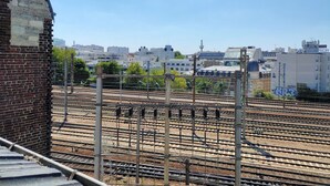 A railway yard with multiple tracks and overhead electrical lines, surrounded by urban buildings. - Charming 2 rooms Clichy Levallois 5 min by train from Paris Saint Lazarre (Clichy)