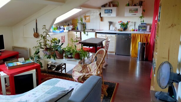 A cozy living room with a sofa, a dining table, and a kitchen area with a refrigerator and various kitchen items. - Charming 2 rooms Clichy Levallois 5 min by train from Paris Saint Lazarre (Clichy)