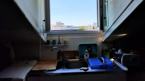 A small kitchen with a window overlooking a cityscape. - Charming 2 rooms Clichy Levallois 5 min by train from Paris Saint Lazarre (Clichy)
