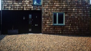 A modern building with a sloped roof, two visible windows, and a garage door. - Camber Sands House
Luxury 5 En-Suite bedrooms, minutes from beach. Dog friendly! (Camber)