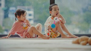 Two children sitting by a window with a view of greenery outside. - Rustic House (Hai Phong)