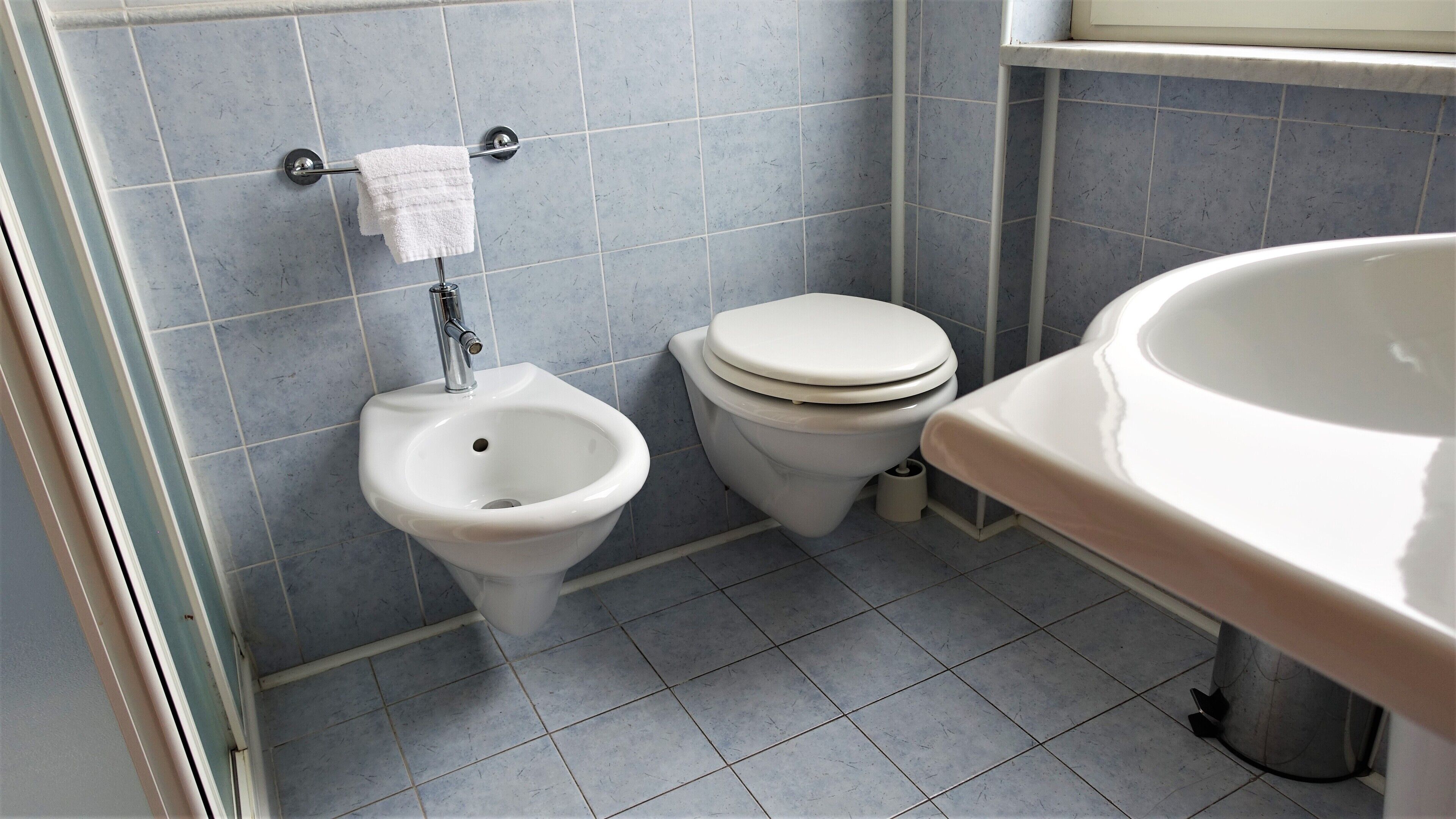 Une salle de bain équipée d’un bidet, de toilettes et d’un lavabo.