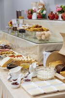 Una mesa de buffet con diversos alimentos, como frutas, quesos y pan.