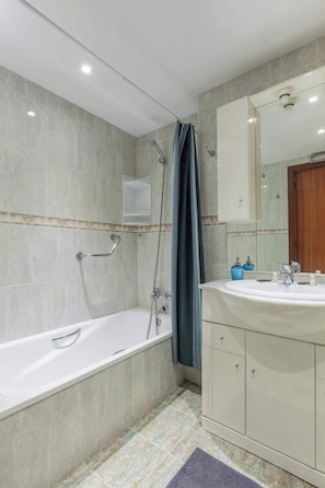 Bathtub, hair dryer, towels, shampoo