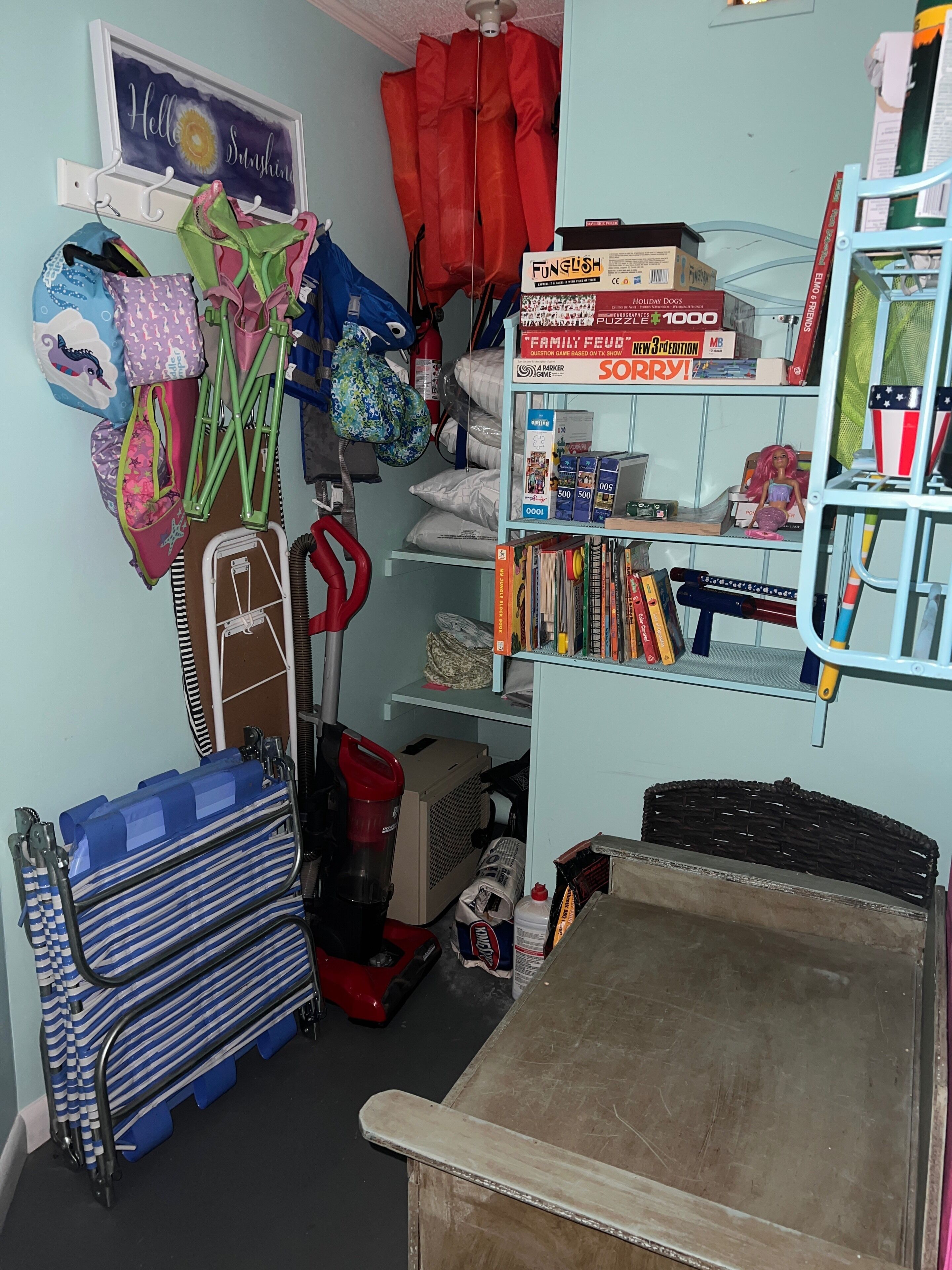 A cluttered storage area with shelves, bags, and various items.