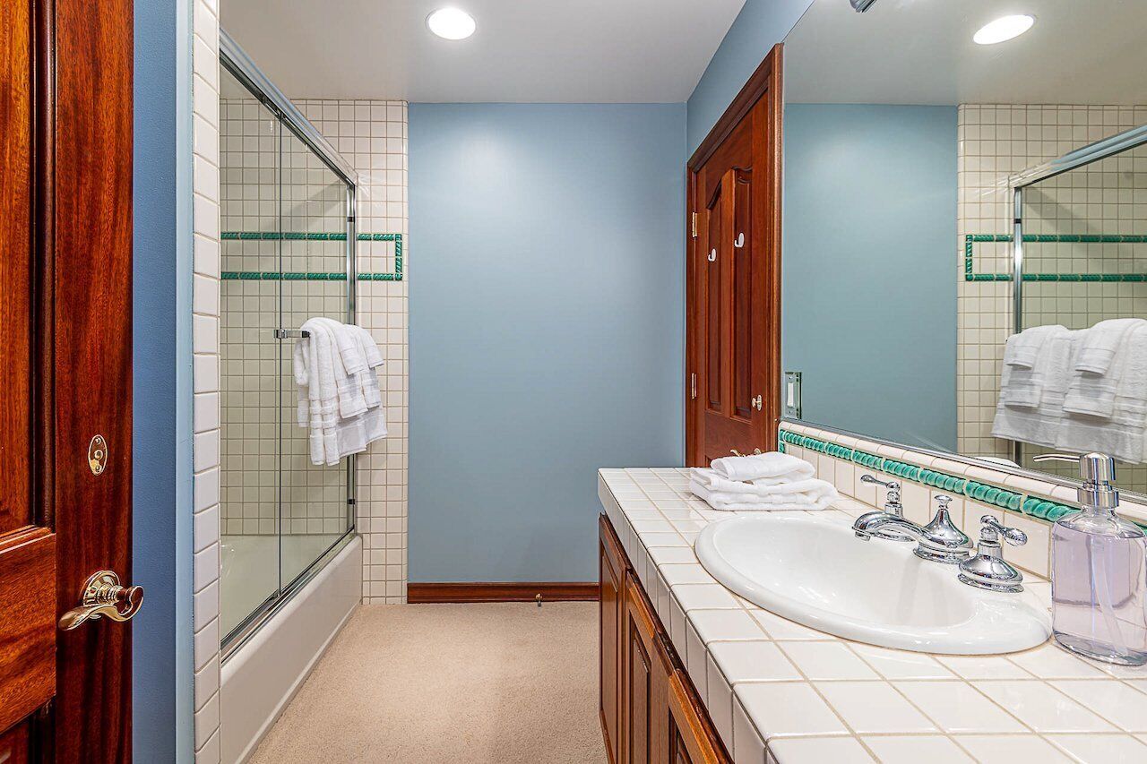 A bathroom with a bathtub, a sink, and a mirror.