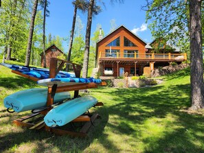 A lodge with a wooden exterior, a balcony, and a stone pathway leading to the entrance.