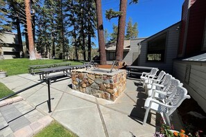 Enjoy al fresco dining and cooking in this outdoor patio area with a fire pit, picnic tables, and a grill.