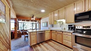 Enjoy cooking in this well-equipped kitchen with a central island, dishwasher, stove, and microwave.