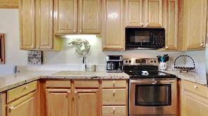 Fully equipped kitchen with a stainless steel oven, microwave, and coffee maker.
