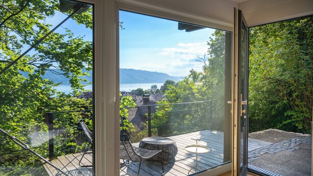 A balcony with a view of a lake and mountains, furnished with a table and chairs. - Modern Minimalistic Seeblick Design Studio mit Küche, Terrace und Parkplatz (Sipplingen)