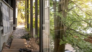 A wooden deck leading to a covered outdoor area with a tree and a glass wall. - Modern Minimalistic Seeblick Design Studio mit Küche, Terrace und Parkplatz (Sipplingen)