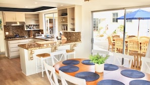 A modern kitchen with granite countertops, white cabinetry, and a central island. - Modern Home, Multi Unit, Relaxing Spacious Patio Ready for Fun! (Laguna Beach)