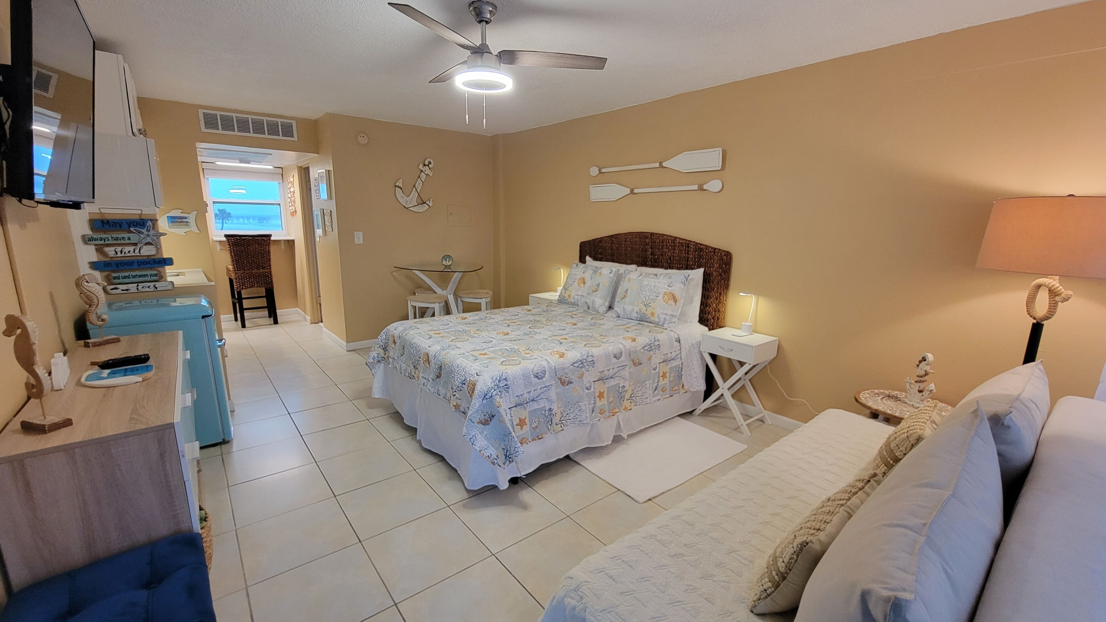 A bedroom with a bed, bedside tables, a desk, and a chair.