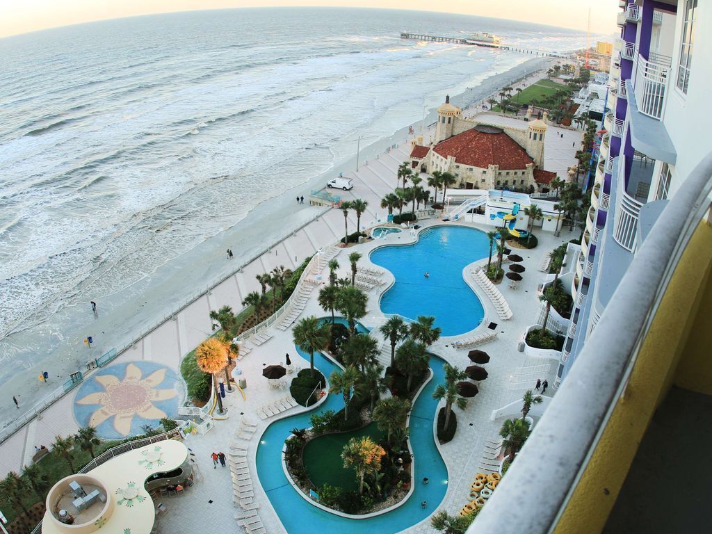 A hotel with a pool area, a beach, and a pier.