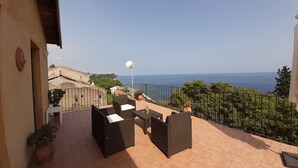 A terrace with outdoor furniture, a view of the sea, and a clear sky. - Lemon's house by the sea (Sicilia)