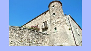 A stone building with a tower and a balcony.