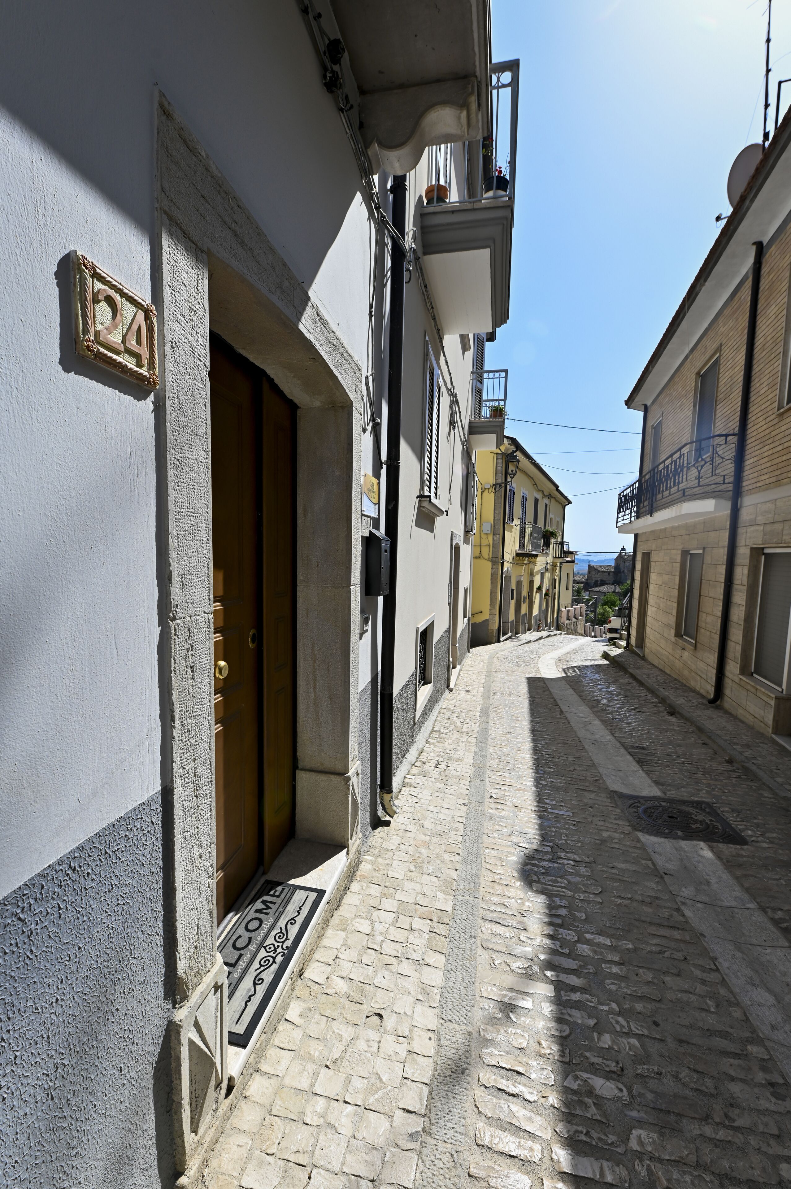 A narrow cobblestone street with buildings on either side.