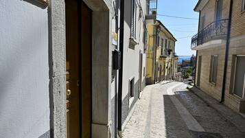 A narrow cobblestone street with buildings on either side.
