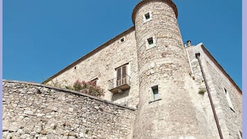 Un bâtiment en pierre doté d’une tour et d’un balcon.