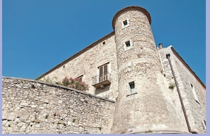 Um edifício de pedra com uma torre e uma varanda.
