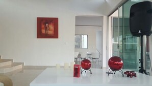 Un intérieur moderne avec une table blanche, un téléphone public rouge et un objet sphérique rouge.