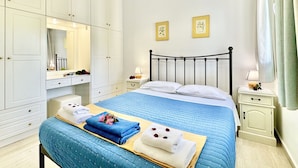 Un dormitorio con cama, mesita de noche, armario y lámpara colgante.