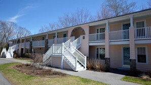 A two-story motel with a central staircase, a covered porch, and a number '5' sign. - Quiet resort condo close to Goose Rocks beach (Kennebunkport)