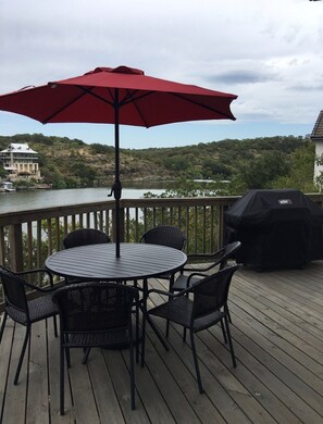 Relax and dine on the deck, surrounded by a serene lake view and hilly landscape.