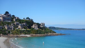 A coastal town with a beach, historic buildings, and a lighthouse.