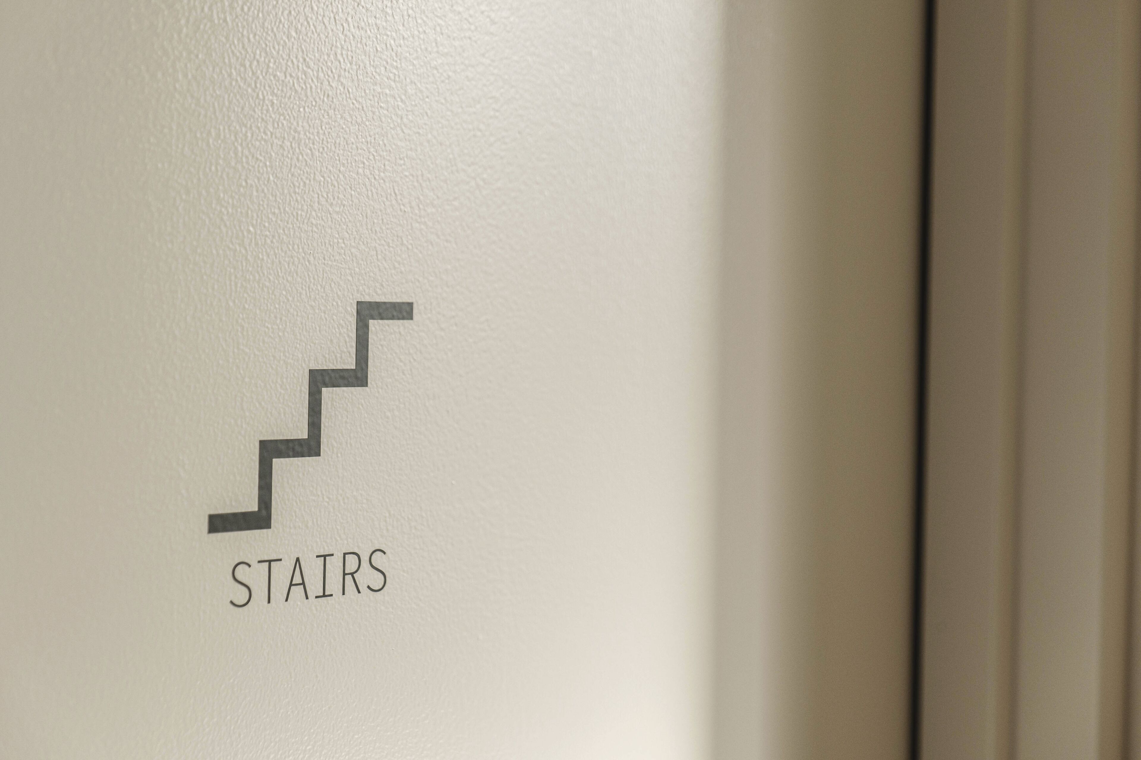A sign with a stair symbol and the word "STAIRS" indicating the location of the staircase.