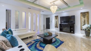 A modern living room with a sofa, coffee table, and a flat-screen TV.