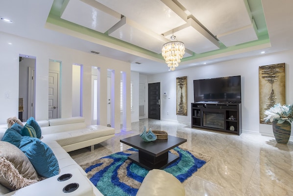 Un salon moderne avec un canapé, une table basse et un téléviseur à écran plat.