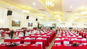 A large banquet hall with rows of tables and chairs, each with red tablecloths and white chair covers. - Bong Hong Hotel (Sa Dec)