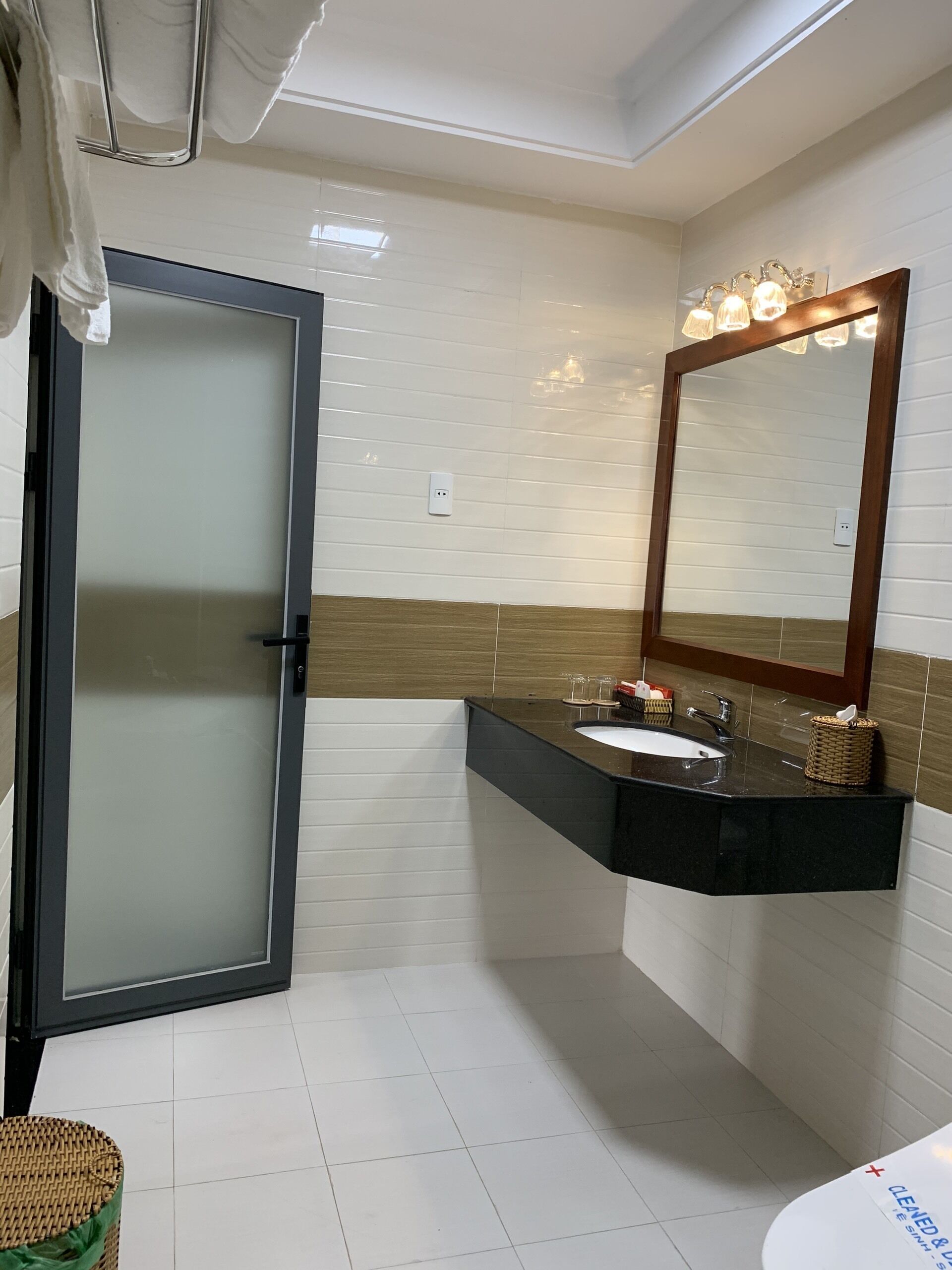 Un bagno moderno con cabina doccia in vetro, lavabo con specchio e water.