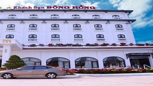 A multi-story building with a white facade, balconies, and a car parked in front. - Bong Hong Hotel (Sa Dec)